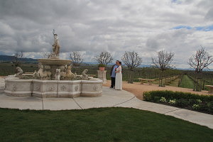 Vineyard wedding ceremony venue with fountain and wedded couple
